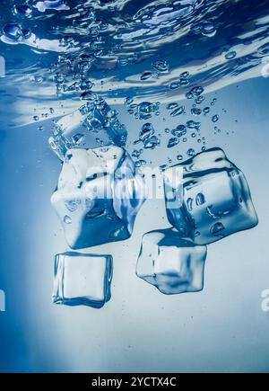 Ice cubes falling under water Stock Photo