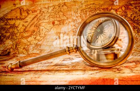 Vintage Compass and magnifying glass lies on an ancient world map ...