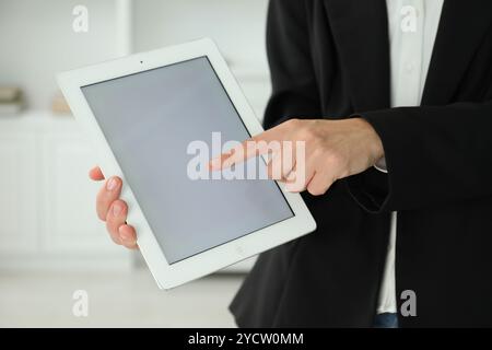 Businesswoman using tablet indoors, closeup. Modern technology Stock Photo