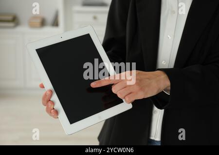 Businesswoman using tablet indoors, closeup. Modern technology Stock Photo