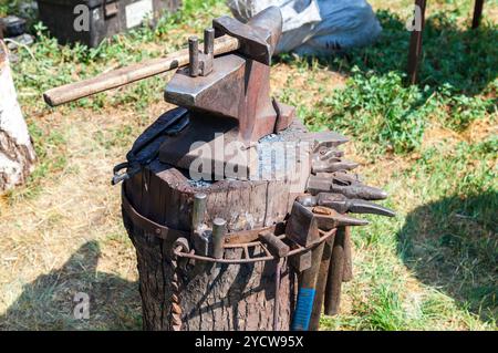 Old anvil with blacksmith tools at the outdoors Stock Photo