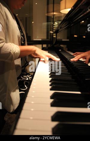 Kuala Lumpur, Malaysia - November 26, 2018: Close-up of a woman hands playing a black elegant piano Yamaha. Stock Photo