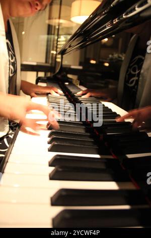 Kuala Lumpur, Malaysia - November 26, 2018: Close-up of a woman hands playing a black elegant piano Yamaha. Stock Photo