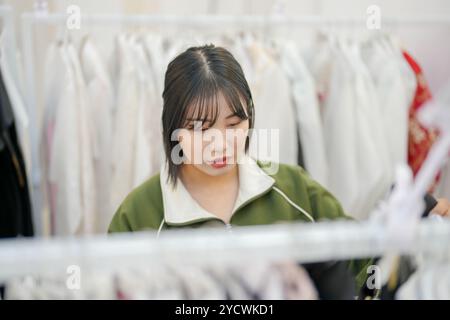A Korean couple, a man in his 30s and a woman in her 20s, are harmoniously choosing clothes to wear at a hanbok rental shop in Seoul, South Korea. Stock Photo
