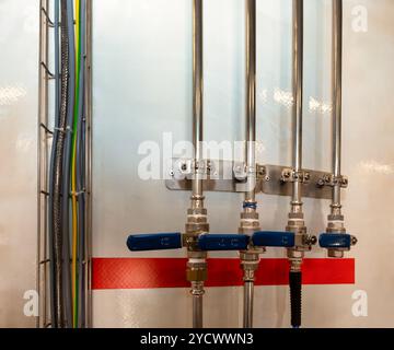 pipework flush mounted, with ball valve and stainless steel pipes with couplings for Plumbing Stock Photo