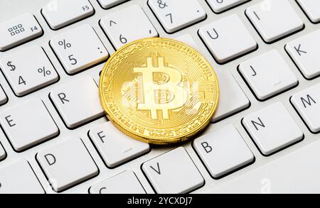 Cryptocurrency of the golden bitcoin lying over computer keyboard. Business concept of worldwide cryptocurrency Stock Photo