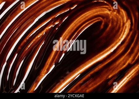 Top view of a rich, wavy texture of melted chocolate, showcasing its glossy, luxurious swirls with white accents. Perfect as a background or a detail Stock Photo
