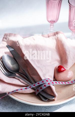 Elegant table setting featuring a pink-themed arrangement with heart accents, ideal for celebratory occasions like Valentine's Day or anniversaries In Stock Photo