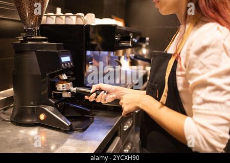 Barista in a chocolate store skillfully handles an espresso machine, preparing a fresh coffee The dark and sleek espresso machine stands out against a Stock Photo