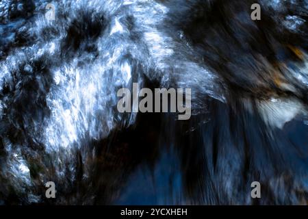 An abstract, flowing water texture captured in motion, creating a dynamic and fluid visual effect. Stock Photo