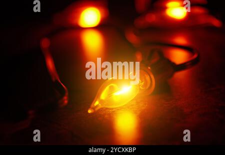 Close-up image of illuminated warm yellow Christmas lights glowing softly against a dark, blurred background, creating a festive and cozy holiday atmo Stock Photo