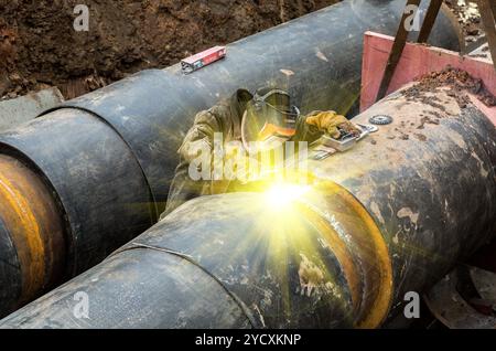 Worker with protective mask welding metal with sparks and smoke Stock Photo