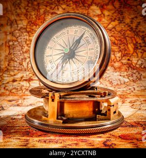 Vintage compass lies on an ancient world map. Stock Photo