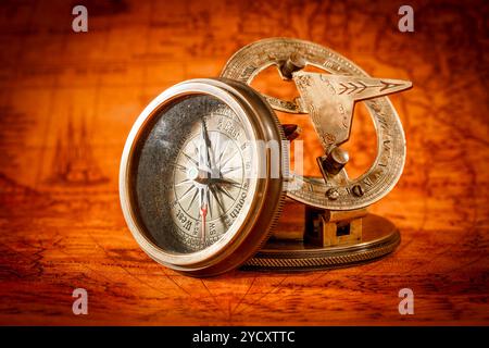 Vintage compass lies on an ancient world map. Stock Photo