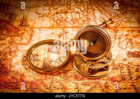 Vintage compass lies on an ancient world map. Stock Photo