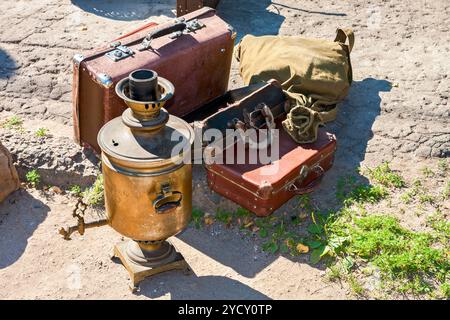 Vintage travel luggage with old suitcases and copper samovar in sunny day Stock Photo