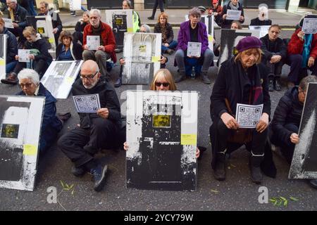 London, UK. 24th October 2024. A protester holds a picture of Roger Hallam as activists stage the ‘Free Political Prisoners’ protest exhibition outside the Ministry of Justice in London, calling on the Attorney General to free the climate activists and other protesters currently in UK prisons. The protesters taking part in the exhibition sat down outside the MOJ with pictures of activists in jail and of other political prisoners. Credit: Vuk Valcic/Alamy Live News Stock Photo