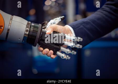 Hand of a businessman shaking hands with a Android robot. Stock Photo
