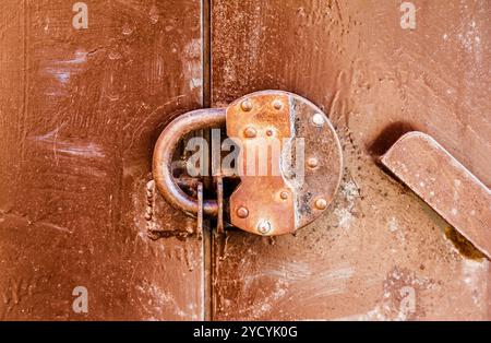 Rusty padlock on an old metal door Stock Photo