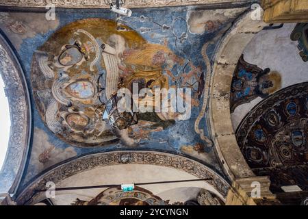 A painted archway at the entrance to the Palazzo dell'Archiginnasio bears, in its vault, a large coat of arms with a mitre and putti on a blue ground; a lantern hangs from the ceiling. The building was erected in 1562/63 under Pope Pius IV and served as the seat of the University of Bologna until 1803. Piazza Galvani, Bologna, Emilia-Romagna, Italy. Stock Photo