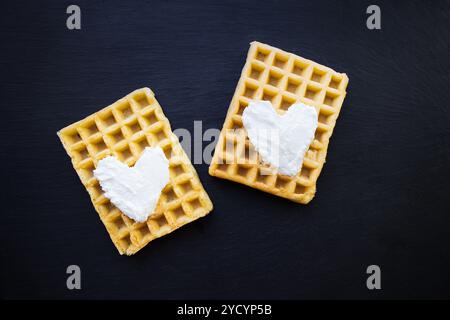 Delicious belgian waffles with cream on a black background. Stock Photo