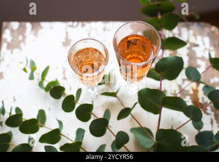 Eucalyptus branches on an old table with a glass of rose wine Stock Photo