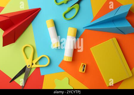 Flat lay composition with glue, scissors and other stationery on color background Stock Photo