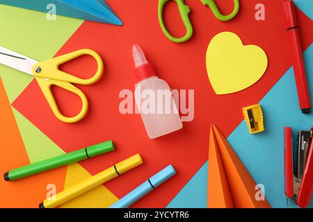 Flat lay composition with glue, scissors and other stationery on color background Stock Photo