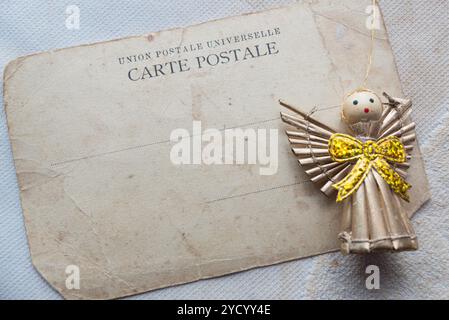 blank vintage postcard with toy angel figurine Stock Photo