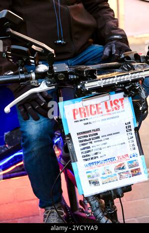 A price list per person for trips around central London displayed on a pedicab taxi in Soho. Stock Photo