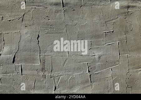 Grey wall, texture, background. Gray multi-layered wall covering. Rough, uneven surface. Cement plaster on a brick wall. Concrete poured surface Stock Photo