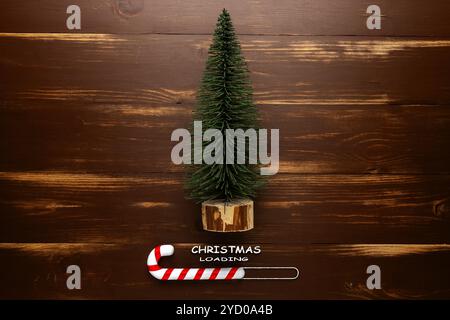 Minimal Christmas loading concept. Fir tree and candy cane On wooden rustic table. Stock Photo