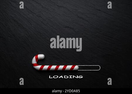 Creative Christmas concept made of Candy cane on black stone background. Minimal Christmas loading concept. Stock Photo