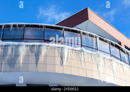 Transparent icicles on the roof of the house Stock Photo