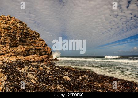 landscape of waves crashing against the rocky cliff coastline of the cape of good hope south africa  with interesting cloud formations Stock Photo