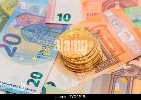 A Stack of Bitcoin Coins on the Euro Banknotes. Money Saving, Cryptocurrency, Blockchain and Anonymous Payments Concept Stock Photo
