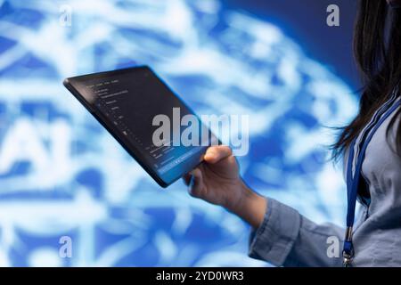 Software developer with tablet programming artificial intelligence computing simulating human brain. Close up of IT professional using device, building AI machine learning algorithms Stock Photo