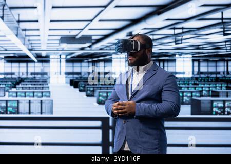 Admin working in data center, using VR headset to configure network infrastructure. IT specialist in server hub looking for technical issues using virtual reality technology Stock Photo