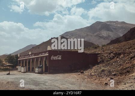 Countryside, Morocco, July 23th 2019: A traditional hut along a dirt road in the Moroccan highlands under a cloudy sky with Coca Cola sign Stock Photo