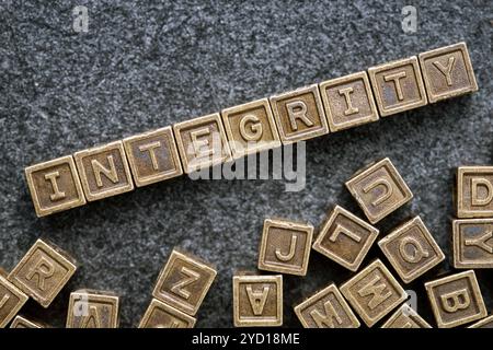 integrity word made from metallic blocks on blackboard surface Stock Photo