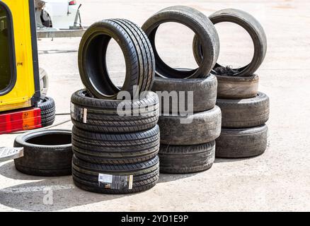 New and used car tires stacked on road Stock Photo