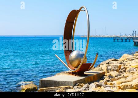 Metal sculpture stands on a rocky shore in Limassol from Cyprus Stock Photo