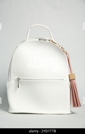 Backpack with pink leather keychain on grey background Stock Photo