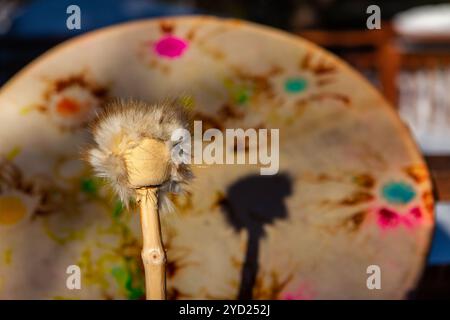 A close-up view of a sacred drum and drumstick, traditionally used by Native American tribes for spiritual ceremonies. Traditional percussion instrume Stock Photo