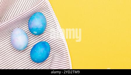 Blue painted eggs on a towel . The religious holiday is Easter. Eggs are seasonal in color. Blue painted eggs. Banner with a pla Stock Photo