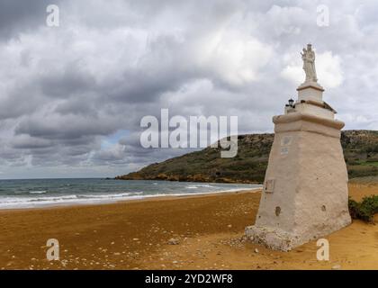 Ramla Bay, Malta, 20 December, 2023: view of the red sand beach and Staue of Our Lady in Ramla Bay on Gozo Island in Malta, Europe Stock Photo