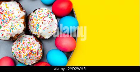 Colored painted eggs on a yellow background. Easter banner. Festive banner with place for text. Religious holiday. Stock Photo