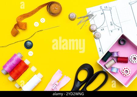 Layout sewing. needlework, craft, sewing and tailoring concept - box with thread spools and buttons on the table. The concept of Stock Photo