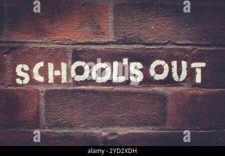 Urban School's Out Stencil Graffiti On A Red Brick Wall Stock Photo