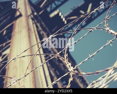 Industrial Concept Image Of Barbed Wire Around A Shipbuilding Crane Stock Photo